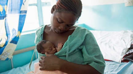 En mamma håller sin nyfödda bebis på en förlossningsklinik i Kenya som stöds av Rädda Barnen.